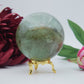 Polished Green Fluorite Sphere 630G 70Mm featuring banded green‑purple hues and glassy clarity - Positive Faith Hope Love